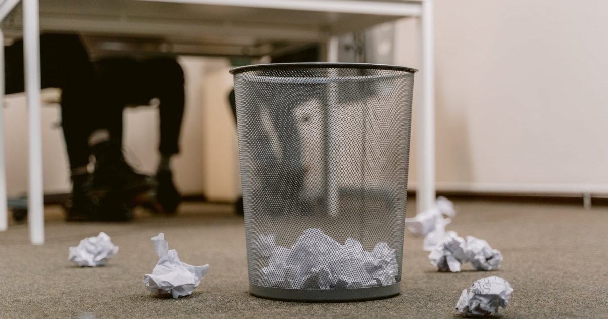 crumpled papers inside the trash bin at the office