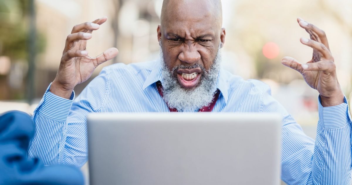 angry black man having video conversation via laptop